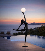 Modern ballet sculpture floor lamp with dancer figure holding illuminated globe in minimalist interior