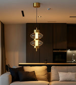 Modern gold and glass pendant light above beige sofa in contemporary living room