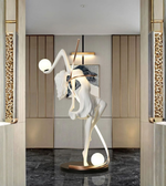 Illuminated dancer sculpture floor lamp with glowing spheres in a luxury modern interior at entrance