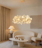 Circular floral chandelier with frosted glass petals in a modern living room.