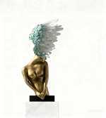 Decorative winged human form floor sculpture with metallic gold finish and artistic feather detailing on white background