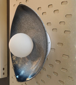 Teardrop-shaped wall sconce with glowing central orb