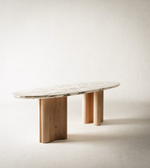 Sculpted marble and wood dining table with a modern design, featuring smooth surfaces and elegant craftsmanship by Daya Worldwide.