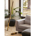 Wooden leaning floor lamp styled near window and indoor plant