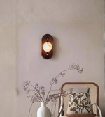 Modern wood and glass wall light mounted above bedside table