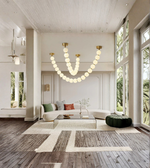 Modern living room with a chandelier, sofa, and large windows.
