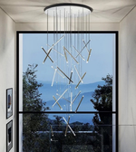 Modern chandelier hanging in a room with a large window view of trees and mountains.