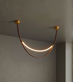 Modern ceiling light fixture with curved design on a neutral wall background
