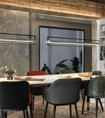 Modern dining room with a long table and chairs, featuring a large window in the background.