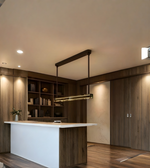 Modern kitchen with wooden cabinets, a white island, and pendant light.