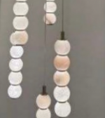 Decorative pendant lights with round, multicolored beads on a plain background