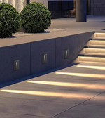 Modern outdoor setting with concrete steps and wall lights.