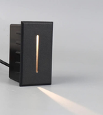 Black outdoor light fixture with a horizontal copper accent on a gray background