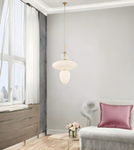 Modern interior with a pendant light, pink pillow, and decorative elements.