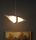 Modern pendant light fixture on a dark wall with a framed painting below.