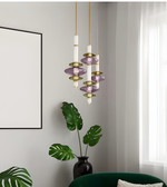 Modern pendant light fixture in a room with a plant and framed picture on the wall.