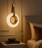 Decorative pendant light hanging above a bed in a bedroom setting.