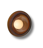Brown ceramic bowl with a light bulb inside on a white background