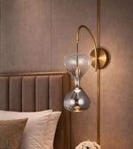 Modern hourglass glass wall light beside luxury bed