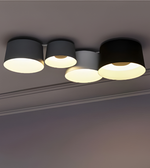 Modern multi-cylinder ceiling light with black and white shades providing warm ambient lighting
