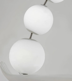 Close-up of a modern ceiling light fixture with spherical glass shades on a neutral background.