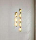 Gold wall sconces with glass shades on a light gray wall.