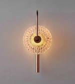 Wall-mounted light fixture with decorative glass shade on a plain background
