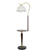 Floor lamp with a white lampshade and wooden base on a white background