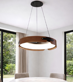Modern pendant light hanging in a room with large windows and greenery outside