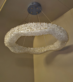 Decorative ceiling light fixture with crystal-like material on a beige wall.