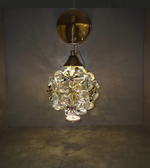 Decorative wall light fixture with crystal-like design on a plain background