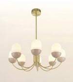 A modern 7-light chandelier with a brushed gold metal frame and frosted white dome glass shades, shown against a plain off-white background.