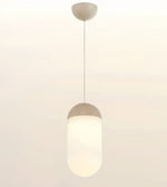 A modern pendant light with a frosted cylindrical shade and a matte beige cap and ceiling mount, shown against a plain off-white background.