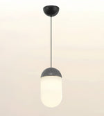 A modern pendant light fixture with a matte black ceiling canopy and cord, featuring a frosted white cylindrical glass shade with a dark gray metallic collar, shown against a plain off-white background.