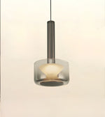 A modern pendant light with a cylindrical brushed metal fixture and a frosted glass shade, shown against a plain off-white background.