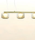 A modern linear pendant light fixture with three clear cylindrical glass shades and a brushed brass or gold-toned metal bar, shown against a plain white background.