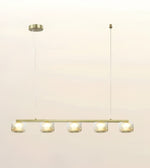 A modern linear chandelier with five clear glass shades and warm white LED lights, suspended from a slim cable with a round canopy on a plain off-white background.