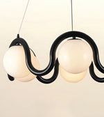A modern multi-light pendant chandelier with three frosted white globe shades and a sculptural black wavy metal frame, suspended against a plain off-white background.