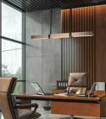 Modern office interior with a wooden desk, brown leather chairs, a long rectangular pendant light, slatted wood wall paneling, and large windows.