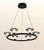 A modern multi-light ring chandelier with a matte black circular frame, silver-toned metal shades, and glowing warm white bulbs, suspended by thin black cords from a round ceiling canopy against a plain light background.