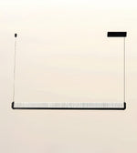 A modern linear pendant light fixture with a textured white diffuser and black metal frame, suspended by two thin cables against a plain beige background.