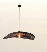 A modern pendant light with a curved black metal frame and a single glowing warm bulb, suspended against a plain light beige background.