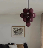 Purple spherical chandelier hanging in a room with a wall art piece.