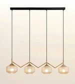 A modern 4-light linear pendant chandelier with textured glass shades and gold-toned geometric accents, suspended from a black horizontal bar against a warm off-white background.