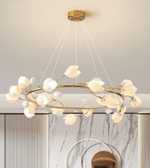 Modern chandelier with gold frame and white bulbs in a room with marble wall.