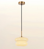 A modern pendant light with a black cord, gold-toned metal ceiling canopy and connector, and a dual-tiered, rounded translucent glass shade that glows warm white.