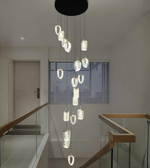 Modern chandelier hanging in a staircase area with a neutral color scheme.