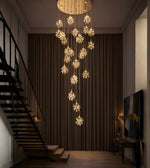Floral crystal cascade staircase chandelier with warm lighting in a luxury double height interior