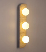 Wall-mounted light fixture with three round lights on a neutral background