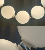 Close-up of a chandelier with white spherical lights against a dark background